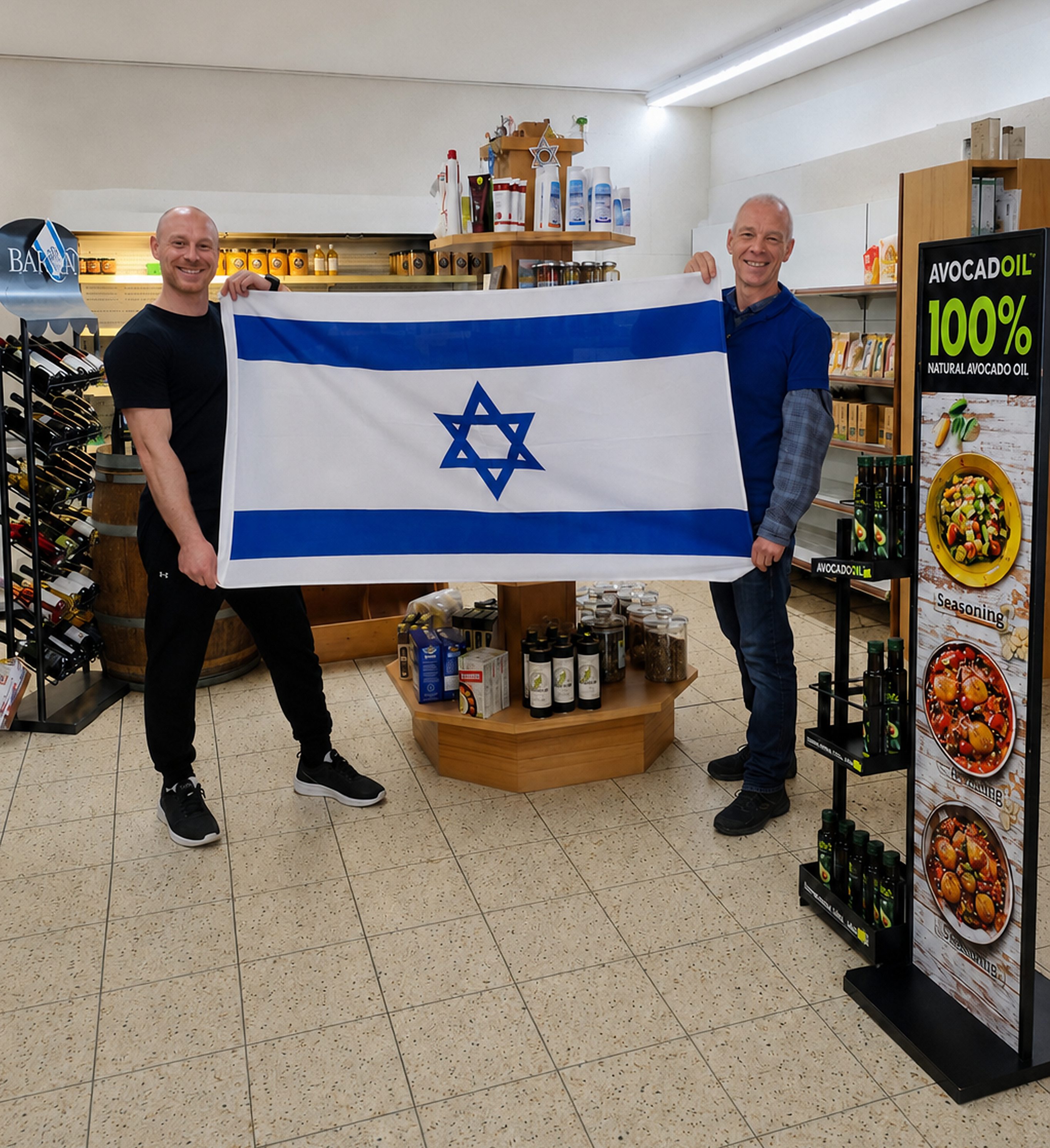 Tobias und Raimund Dieterich mit der israelischen Flagge im Ladengeschäft von Israel Spezialitäten in Lenningen